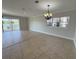 Open-concept living room featuring tile flooring and sliding glass doors that offer lake views at 1554 Corolla Ct, Reunion, FL 34747