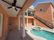 Covered patio with brick pavers, outdoor kitchen, fan and view of pool, spa, outdoor staircase and upper balcony at 1554 Corolla Ct, Reunion, FL 34747