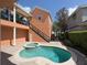 Outdoor living space featuring a kidney shaped pool and attached spa with brick pavers and exterior staircase to upper level at 1554 Corolla Ct, Reunion, FL 34747