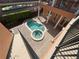 Aerial view of pool and jacuzzi surrounded by a brick patio and a green hedge at 1554 Corolla Ct, Reunion, FL 34747