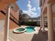 Backyard view of a kidney shaped pool and spa from covered patio with brick pavers and exterior staircase at 1554 Corolla Ct, Reunion, FL 34747