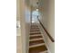 Bright staircase with hardwood steps, white risers, and a window offering natural light at 1554 Corolla Ct, Reunion, FL 34747
