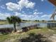 Scenic view of the golf course, lake and water fountain from backyard with a palm tree and well-maintained landscaping at 1554 Corolla Ct, Reunion, FL 34747