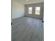 Bright, empty bedroom with wood floors, two windows and fresh, neutral paint at 16358 Sw 27Th Terrace Rd, Ocala, FL 34473