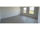 Bright, empty bedroom with wood floors, two windows and fresh, neutral paint at 16358 Sw 27Th Terrace Rd, Ocala, FL 34473