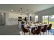 Open dining area features white kitchen, island with barstool seating, and modern lighting at 16358 Sw 27Th Terrace Rd, Ocala, FL 34473