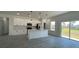 Bright kitchen features white cabinets, an island with seating, and a sliding glass door to the backyard at 16358 Sw 27Th Terrace Rd, Ocala, FL 34473