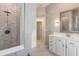 Modern bathroom features a walk-in shower with decorative tile and a white vanity with marble countertops at 205 Torcaso Ct, Winter Springs, FL 32708