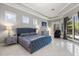 A spacious bedroom featuring a blue upholstered bed, tile floors, and access to the pool at 205 Torcaso Ct, Winter Springs, FL 32708