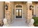 Home entrance featuring double doors, stone pillars, sconces, and two lion statues at 205 Torcaso Ct, Winter Springs, FL 32708