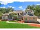 Beautiful two-story home with a well-manicured lawn, red mulch, and mature trees at 205 Torcaso Ct, Winter Springs, FL 32708