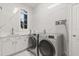 Well-lit laundry room with modern washer and dryer units, along with ample countertop space and storage cabinets at 205 Torcaso Ct, Winter Springs, FL 32708