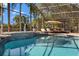 The screened in pool area showcases a clear blue swimming pool, lounge chairs, and lush landscaping around the perimeter at 205 Torcaso Ct, Winter Springs, FL 32708