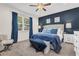 Cozy bedroom with a blue accent wall, large bed, and ample natural light from the window at 2724 Westyn Cove Ln, Ocoee, FL 34761
