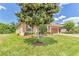 Beautiful home exterior featuring a large magnolia tree, green lawn, and a two-car garage at 2724 Westyn Cove Ln, Ocoee, FL 34761