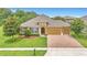 Well-maintained home featuring a brick driveway, lush lawn, and tasteful landscaping with mature trees at 2724 Westyn Cove Ln, Ocoee, FL 34761