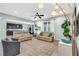 Open living room featuring tiled floors, neutral sofas, ceiling fan, and open view into kitchen at 2724 Westyn Cove Ln, Ocoee, FL 34761