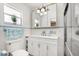 Bright bathroom with white cabinets, tiled walls, and a glass-enclosed shower at 2906 E Grant Ave, Orlando, FL 32806