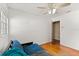 Neutral bedroom with wood floors, ceiling fan, sofa, and door to another room at 2906 E Grant Ave, Orlando, FL 32806