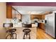 Open-concept kitchen with counter seating, stone accents, and stainless steel refrigerator at 2906 E Grant Ave, Orlando, FL 32806