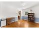 Bright room with wood floors, built-in bookshelf, blue accent walls, desk, and an opening to the kitchen at 2906 E Grant Ave, Orlando, FL 32806