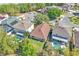Overhead shot of a home, showcasing the roof, backyard, lush trees, swimming pools, and neighborhood layout at 300 Augustine Ct, Oviedo, FL 32765