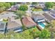 An aerial shot displaying the roof, backyard, and swimming pool of the property, surrounded by lush greenery at 300 Augustine Ct, Oviedo, FL 32765