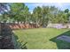 Large grassy backyard with a brick perimeter, complemented by a sturdy wooden fence, and lush trees at 300 Augustine Ct, Oviedo, FL 32765