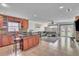 Open kitchen and living area with stone countertops, wooden cabinets and tile floors at 300 Augustine Ct, Oviedo, FL 32765