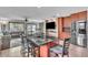 View of kitchen with stainless steel appliances, island with bar stools, and open floor plan at 300 Augustine Ct, Oviedo, FL 32765