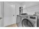This laundry room features a modern, front-load washer/dryer, shelving, and a neutral color palette at 300 Augustine Ct, Oviedo, FL 32765