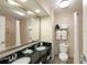 Clean Galleria hotel bathroom with dual vanity and shower with curtain at 3000 Maingate Ln # 504, Kissimmee, FL 34747