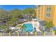 Inviting Galleria hotel pool with palm trees and lounge chairs from above at 3000 Maingate Ln # 504, Kissimmee, FL 34747