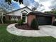 Beautiful home with brick accents, a well-manicured lawn, and a black two-car garage at 3063 Ash Park Loop, Winter Park, FL 32792