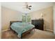 Cozy bedroom showcasing a full bed, dresser, ceiling fan, and lots of natural light from the dual windows at 325 Lakepointe Dr # 303, Altamonte Springs, FL 32701