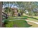 Exterior building view with well-maintained landscaping, mature trees, and a sidewalk at 325 Lakepointe Dr # 303, Altamonte Springs, FL 32701