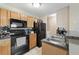 A well-equipped kitchen with black appliances and wooden cabinetry at 325 Lakepointe Dr # 303, Altamonte Springs, FL 32701