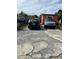 Paved driveway with some potholes leading to an orange single-story home with cars parked at 330 S Buena Vista Ave, Orlando, FL 32835