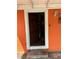 Close up of the front entrance with an orange wall and the door slightly opened at 330 S Buena Vista Ave, Orlando, FL 32835