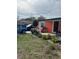 A single-story home featuring a quaint front yard with lush greenery and a vibrant orange exterior at 330 S Buena Vista Ave, Orlando, FL 32835