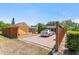Paved driveway showcasing a carport and shed, all enclosed by a wooden fence under a clear sky at 335 W Bay St, Winter Garden, FL 34787