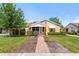 Charming single-story home with a well-manicured lawn and inviting brick walkway, with awning covered front porch at 335 W Bay St, Winter Garden, FL 34787
