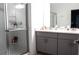 Modern bathroom featuring double sinks, gray cabinetry, and a glass-enclosed shower at 33891 Sky Blossom Cir, Leesburg, FL 34788