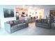 An open-concept living space features a modern kitchen and living room with stainless steel appliances at 33891 Sky Blossom Cir, Leesburg, FL 34788