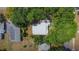 Aerial view of a residential property with mature trees surrounding the roof, driveway, and solar panels nearby at 3600 Merryweather Dr, Orlando, FL 32812