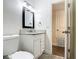Bathroom with granite countertop vanity, white cabinets, and tile flooring, and a door to a hall at 3600 Merryweather Dr, Orlando, FL 32812
