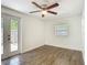 Bedroom featuring hardwood floors, natural light from window and door to the outdoor, and a ceiling fan at 3600 Merryweather Dr, Orlando, FL 32812