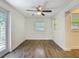 Neutral living room with wood-look tile flooring, ceiling fan, and a window offering natural light at 3600 Merryweather Dr, Orlando, FL 32812
