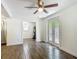 Bright living room with wood-look tile flooring, ceiling fan, and doors leading to the backyard at 3600 Merryweather Dr, Orlando, FL 32812
