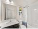 A well-lit bathroom features a shower and tub combination and a dark wood vanity at 3632 Gretchen Dr, Ocoee, FL 34761